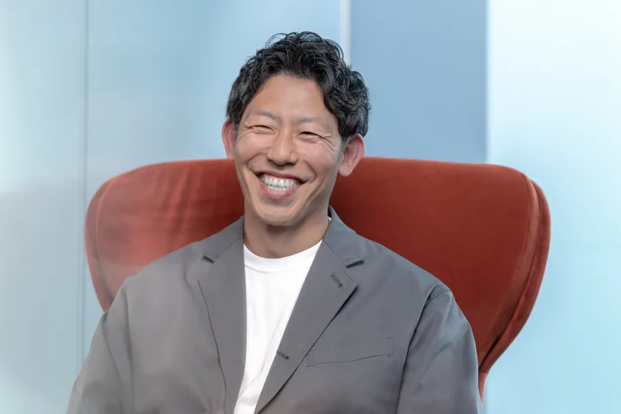 Smiling man seated in a red armchair